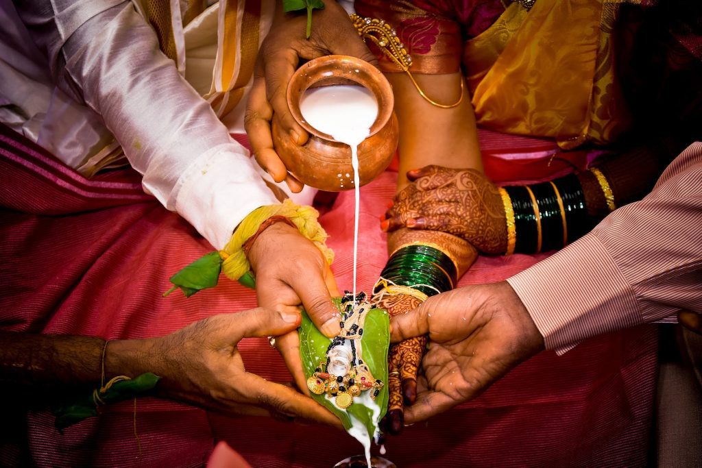 crop newlywed indian couple during traditional wedding ritual